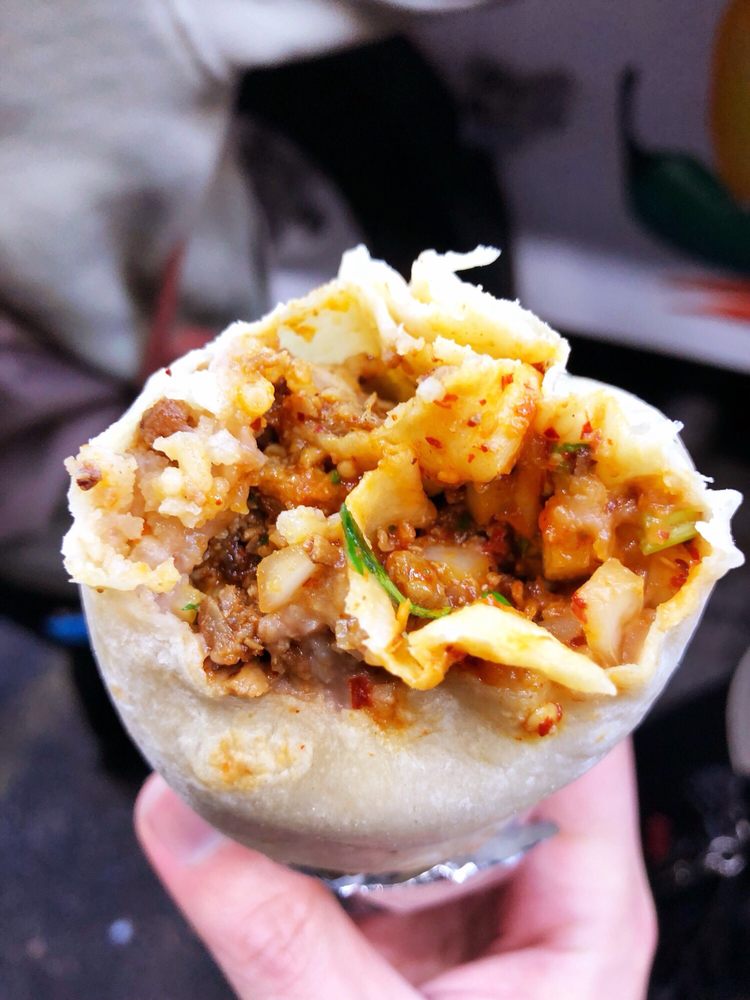 A burrito cut open to show the meat inside