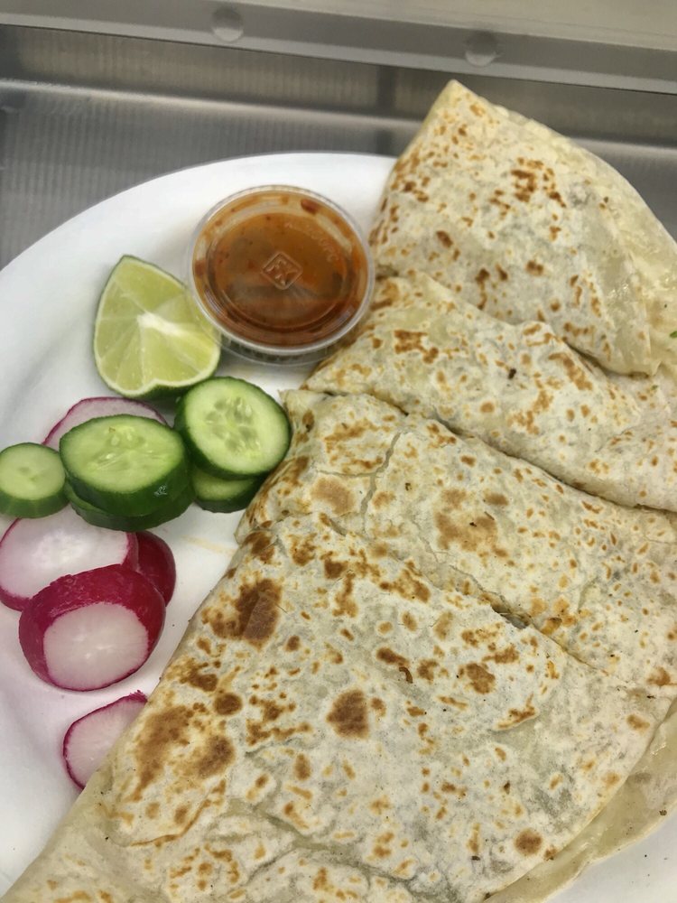 Folded flour quesadilla with radish, cucumber and a cup of salsa